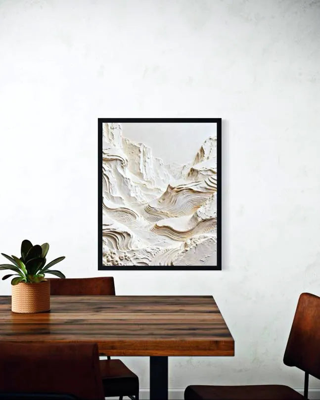 Framed abstract art piece on a wall above a wooden table with chairs.